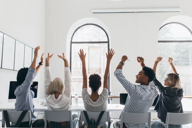 frau-im-formellen-hemd-mit-blonden-haaren-die-haende-winken-sitzen-zwischen-mitarbeitern-im-grossen-hellen-konferenzsaal-foto-von-der-rueckseite-der-mueden-manager-die-sich-waehrend-des-treffens-im-buero-ausdehnen